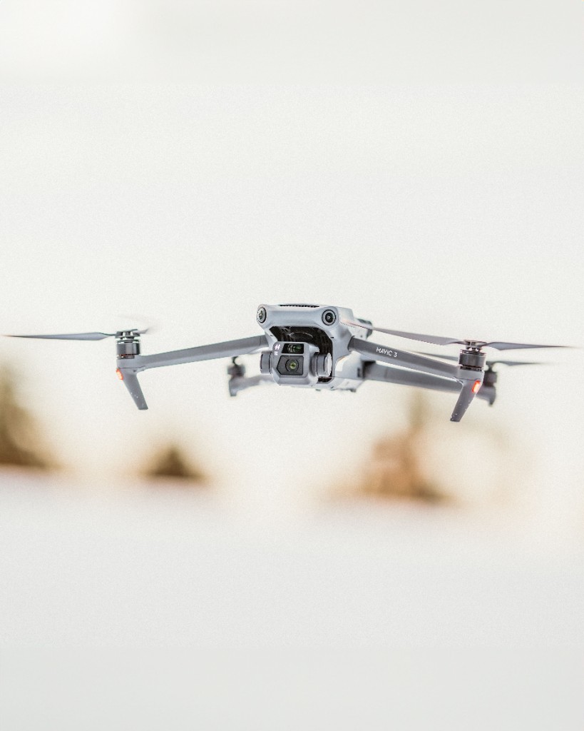 Consumer drone flying over a pale landscape